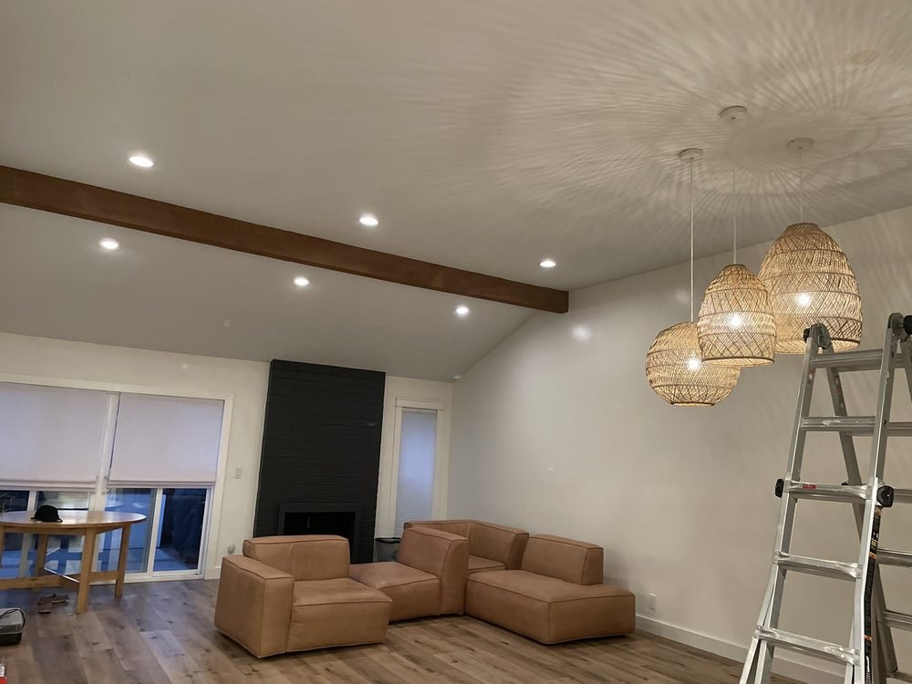 Recessed lighting on a vaulted ceiling with a cluster of three woven pendants