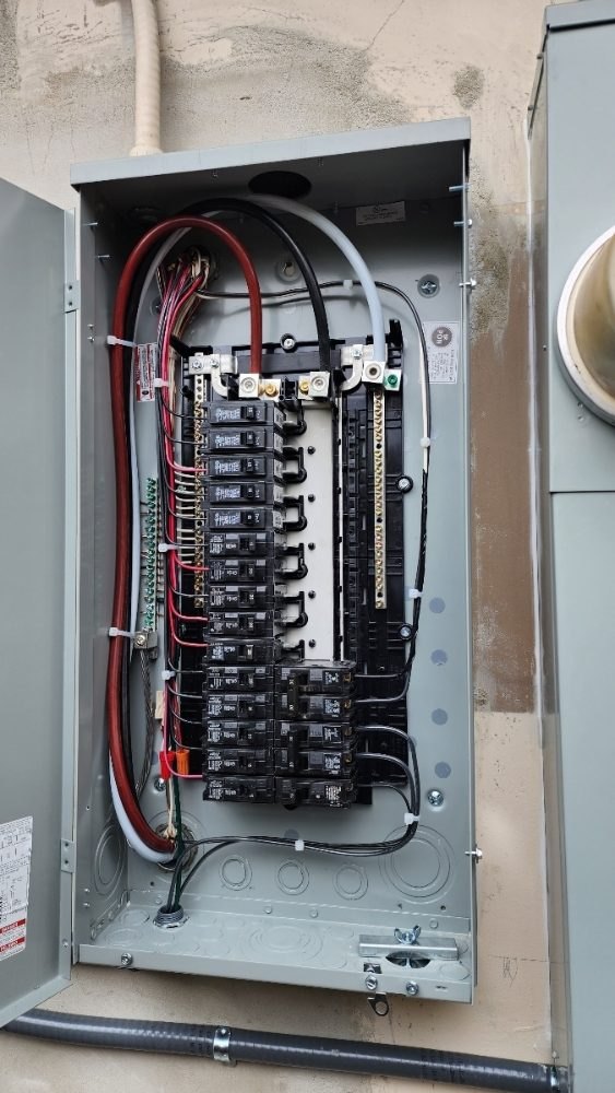 Inside a new main panel: breakers, neutral and ground bars, every conductor labeled and dressed