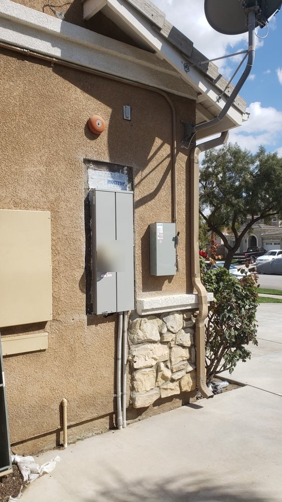 Panel replacement in progress: new meter main set and flashed, conduit run below