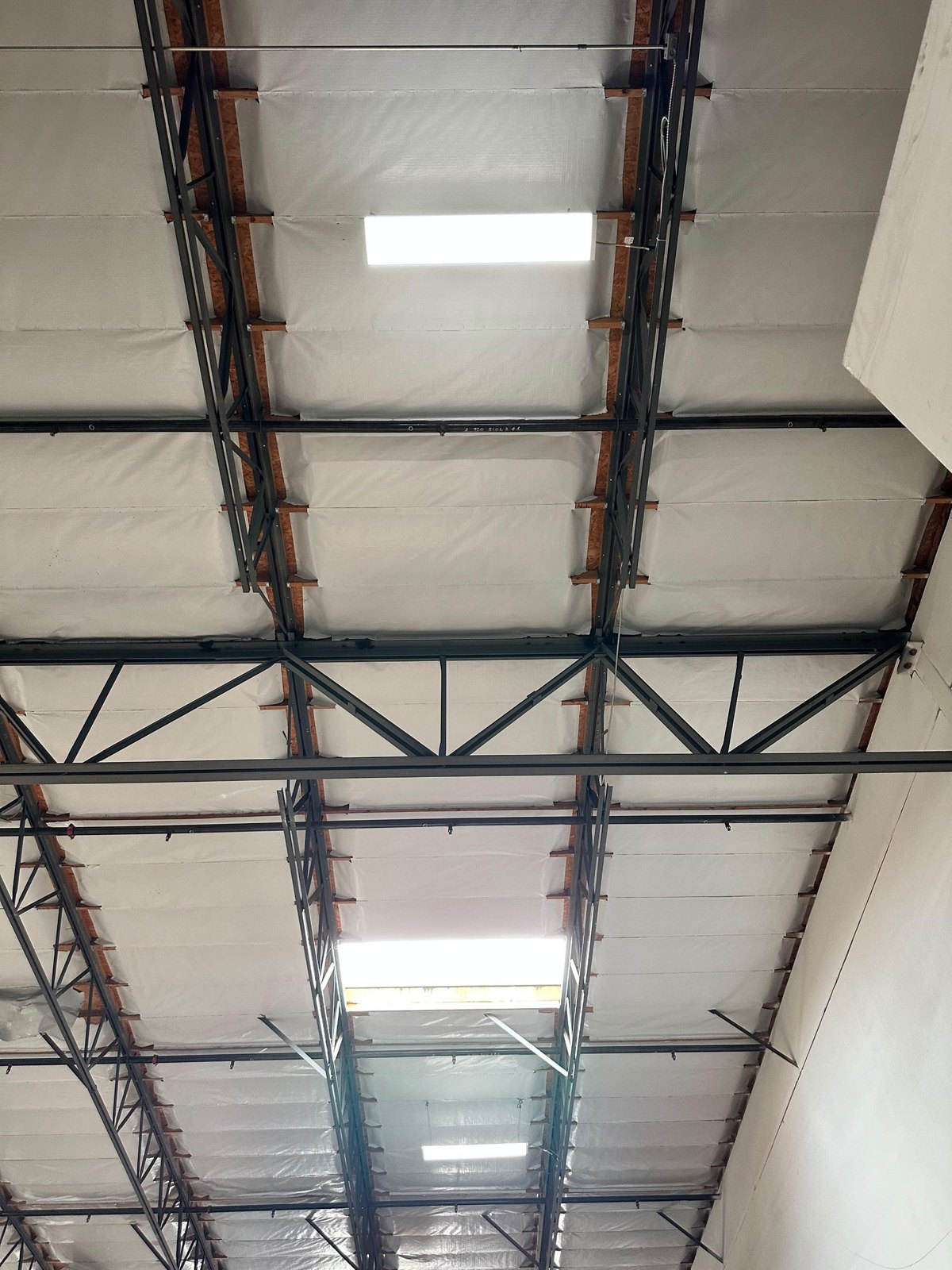 LED fixtures under the steel trusses of a warehouse ceiling